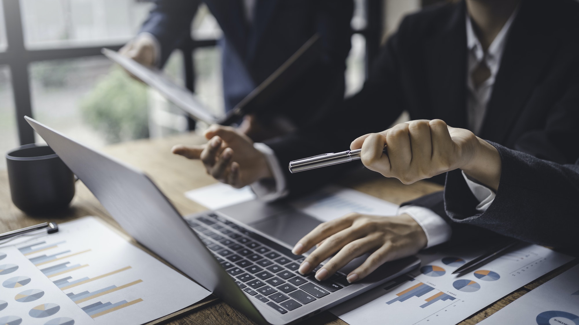 Business people consulting and planning and analyzing marketing on laptop computer in office.