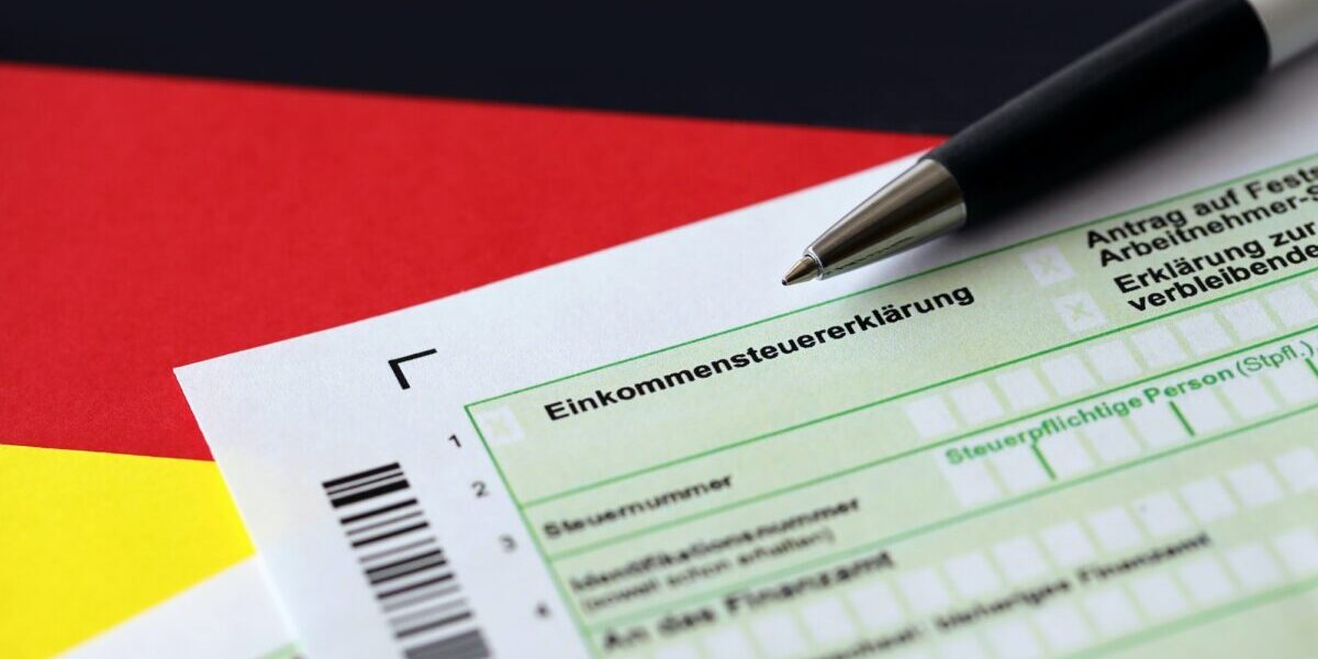 German annual income tax return declaration form with pen on flag close up